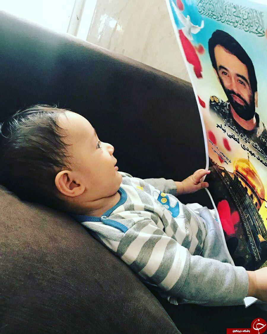 لبخند تأثیرگذار فرزند شش ماهه شهید مدافع حرم بر تصویر پدر +عکس